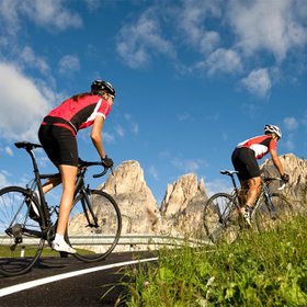 Pareja, hombre y mujer, disfrutando de una ruta de ciclismo en un ambiente montañoso.